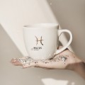 Kubek 300 ml - Ryby / Pisces Zbliżenie na złote zdobienie na białym kubku porcelanowym Ryby / Pisces Nadzwyczajnie.pl