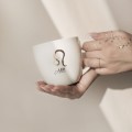 Kubek 300 ml - Lew / Leo Zbliżenie na złote zdobienie na białym kubku porcelanowym Lew / Leo Nadzwyczajnie.pl