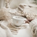 Biała filiżanka porcelanowa ze spodkiem 250 ml - napis moja złota babcia z motywem Złotego serca na dzień babci dla babci Filiżanka porcelanowa ze złotym sercem ze spodkiem - Moja złota babcia Nadzwyczajnie.pl — widok z boku na białym tle