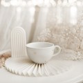 Biała filiżanka porcelanowa 250 ml ze spodkiem - Motyw złotych serduszek na walentynki dla niej Filiżanka porcelanowa ze złotym zdobieniem ze spodkiem - ZŁOTE SERDUSZKA Nadzwyczajnie.pl — widok z boku na białym tle