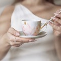 Biała filiżanka porcelanowa ręcznie malowana 200 ml ze spodkiem z cienkim rantem dla koneserki kawy na urodziny  Biały filiżanka porcelanowa Nadzwyczajnie.pl ze złotym zdobieniem i napisem Ręcznie malowana ze spodkiem z CIENKIM RANTEM