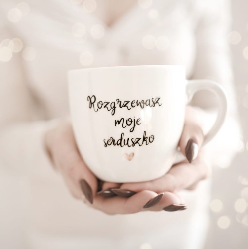 Biały kubek porcelanowy Nadzwyczajnie.pl ze złotym sercem i napisem Rozgrzewasz moje serduszko — 300 ml