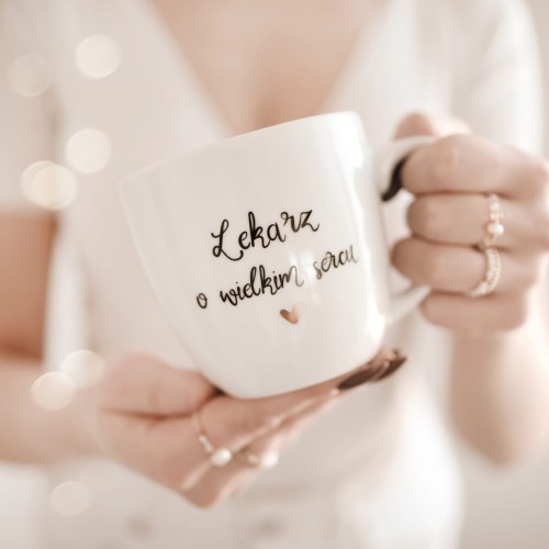 Biały kubek porcelanowy Nadzwyczajnie.pl ze złotym sercem i napisem Lekarz o wielkim sercu — 300 ml