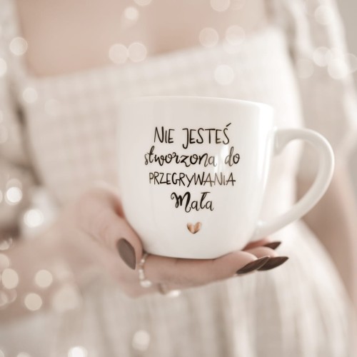Biały kubek porcelanowy Nadzwyczajnie.pl ze złotym zdobieniem i napisem NIE JESTEŚ stworzona do PRZEGRYWANIA +