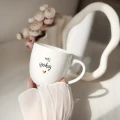 Biały kubek porcelanowy 300 ml - motyw złotego serca z napisem Mój spokój dla ukochanej osoby na walentynki kubek-300ml-slub-moj-spokoj-zlote-serce.webp