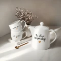 Zestaw biały porcelanowy dzbanek 1 litr i 2 kubki porcelanowe 300 ml - motyw złotego serca z napisami Na długie rozmowy oraz Do końca życia i jeden dzień dłużej dla pary na rocznicę ślubu 3P4A9128.webp