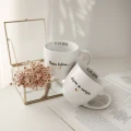 Zestaw 2 białych kubków porcelanowych 300 ml - motyw złotego serca z napisem Nasza historia dopiero się zaczyna oraz datą wewnątrz dla zakochanych na ślub 3P4A9181.webp