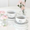 Zestaw 2 białych filiżanek porcelanowych 250 ml ze spodkami - napis żona i mąż z datą i złotym serduszkiem dla małżonków na każdą okazję Zbliżenie na złote zdobienie na białym filiżance porcelanowej filiżanek 250 ml ze spodkami - Żona i Mąż z datą i złotym