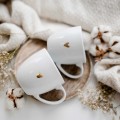Zestaw 2 białych kubków porcelanowych 300 ml - napisy kocham cię i ja ciebie też z motywem złotego serca na walentynki dla pary Zestaw porcelanowy ze złotym sercem kubków 300 ml - Kocham cie Ja ciebie Też Nadzwyczajnie.pl — widok z boku na białym tle