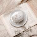 Biała filiżanka porcelanowa 250 ml ze spodkiem - wzór nakrapiany złotem na imieniny dla miłośniczki kawy Biały filiżanka porcelanowa Nadzwyczajnie.pl ze złotym zdobieniem i napisem ze spodkiem - Nakrapiana złotem — 250 ml