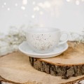Biała filiżanka porcelanowa 250 ml ze spodkiem - wzór nakrapiany złotem na imieniny dla miłośniczki kawy Filiżanka porcelanowa ze złotym zdobieniem ze spodkiem - Nakrapiana złotem Nadzwyczajnie.pl — widok z boku na białym tle