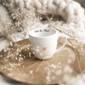 Biały kubek porcelanowy 300 ml - napis bądź tu i teraz ze złotym sercem dla miłośników uważności na urodziny Kubek porcelanowy ze złotym sercem bądź tu i teraz Nadzwyczajnie.pl — widok z boku na białym tle