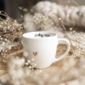 Biały kubek porcelanowy 300 ml - motyw złotego serca z napisem Szukaj magii dla przyjaciółki na urodziny Zbliżenie na złote zdobienie serca na białym kubku porcelanowym Szukaj magii Nadzwyczajnie.pl