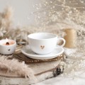 Biała filiżanka porcelanowa 250 ml ze spodkiem - motyw złotego serca z napisem na dnie doceniam codzienność dla bliskiej osoby na podziękowanie Filiżanka porcelanowa ze złotym sercem ze spodkiem - + doceniam codzienność NAPIS NA DNIE Nadzwyczajnie.pl — widok z boku