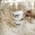 Zestaw 2 białych kubków porcelanowych 500 ml - motyw złotego serca i napisów boski mąż boska żona dla małżonków na ślub Zbliżenie na złote zdobienie serca na białym zestawie porcelanowym kubków 500 ml - Boski Mąż Boska Żona Nadzwyczajnie.pl