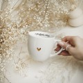 Biały Kubek Porcelanowy 300 ml - Motyw Złotego Serca i Napis Z Pozytywną Energią dla Przyjaciółki na Dzień Kobiet Zbliżenie na złote zdobienie na białym kubku porcelanowym Biały Kubek Porcelanowy 300 ml - Motyw Złotego Serca i Napis Z